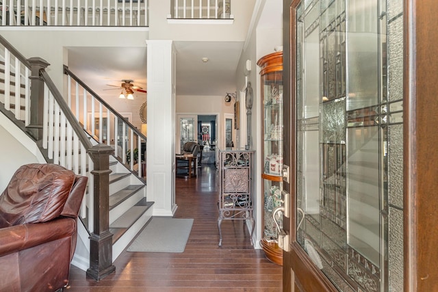 entrance foyer with stairway, decorative columns, a ceiling fan, and wood finished floors