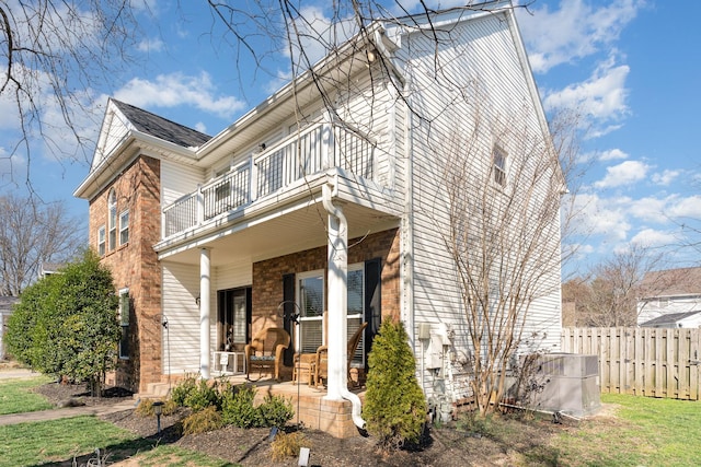 exterior space with a porch, a balcony, and fence