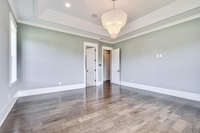 unfurnished room featuring a tray ceiling, baseboards, and an inviting chandelier