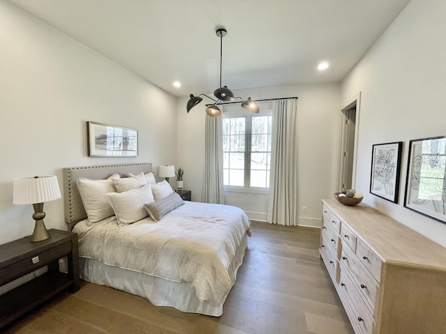 bedroom with recessed lighting, wood finished floors, and baseboards