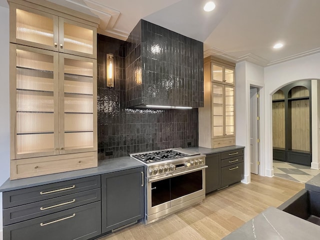 kitchen with double oven range, recessed lighting, gray cabinets, glass insert cabinets, and light wood-style floors