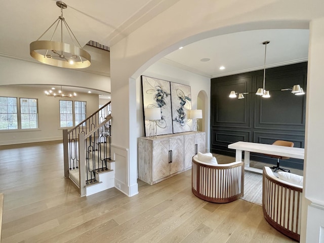 interior space featuring ornamental molding, wood finished floors, recessed lighting, an inviting chandelier, and baseboards