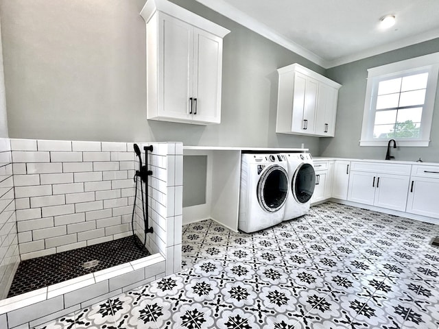 washroom featuring a sink, cabinet space, crown molding, and washer and clothes dryer