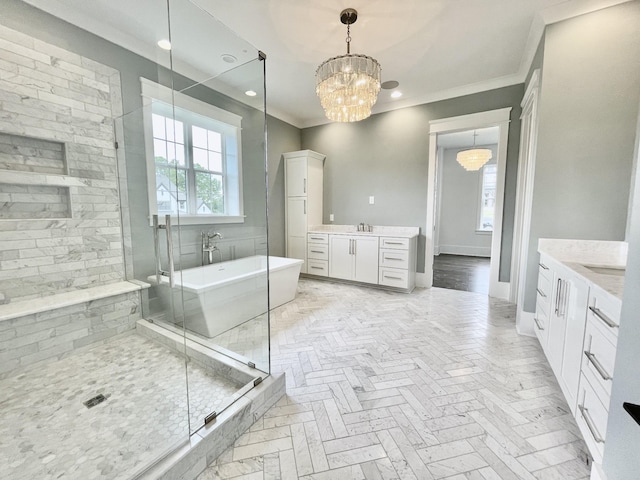 bathroom featuring a freestanding tub, two vanities, a stall shower, ornamental molding, and a chandelier