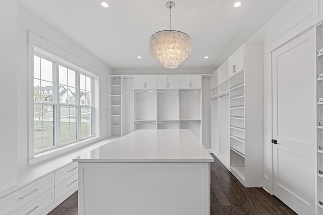 walk in closet featuring an inviting chandelier and dark wood-style flooring