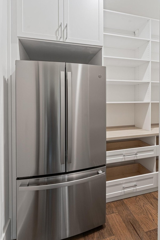 room details with white cabinetry, dark wood-style floors, and freestanding refrigerator