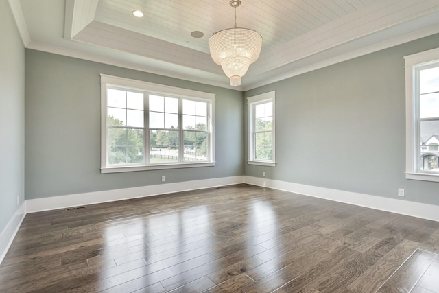 spare room with dark wood-type flooring, baseboards, a tray ceiling, ornamental molding, and a notable chandelier