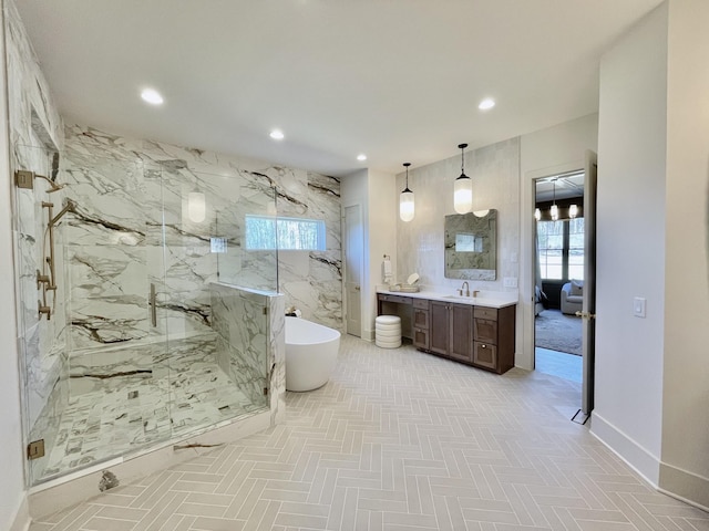 bathroom with vanity, baseboards, a marble finish shower, a soaking tub, and recessed lighting