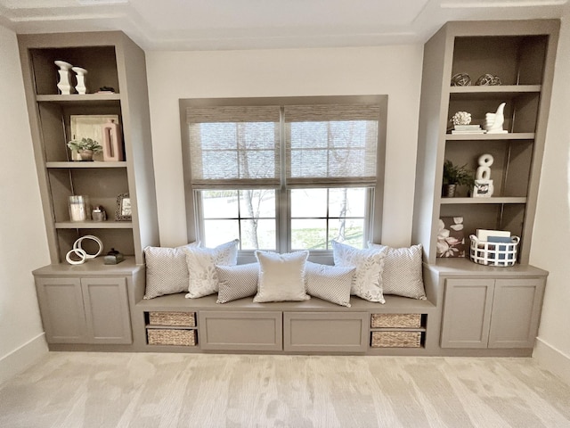 sitting room featuring built in shelves and baseboards