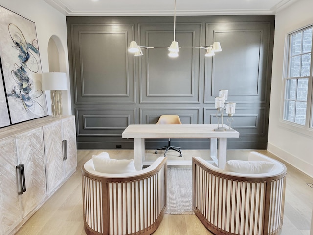 office area with light wood-style floors, ornamental molding, and a decorative wall