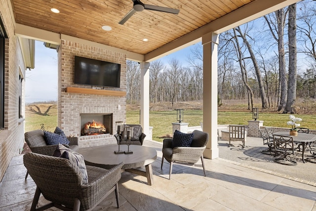 view of patio / terrace with a ceiling fan and an outdoor brick fireplace