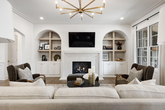 living room with a notable chandelier, built in shelves, dark wood-type flooring, and ornamental molding