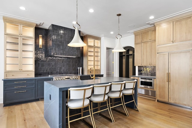 kitchen with paneled fridge, dark countertops, light wood-style flooring, and light brown cabinetry