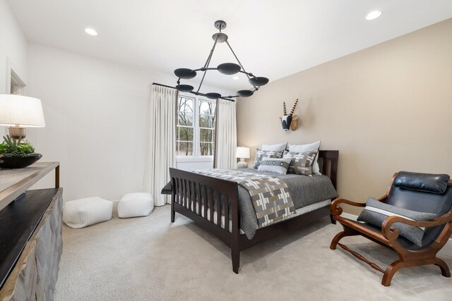 bedroom featuring light carpet, a chandelier, and recessed lighting