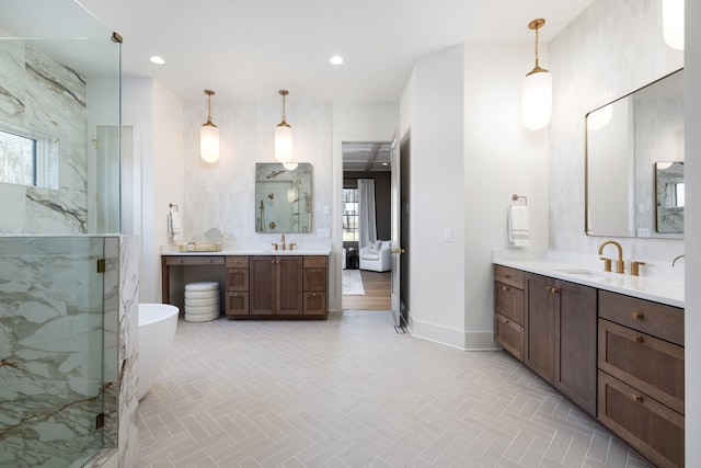 bathroom with a marble finish shower, a wealth of natural light, and a sink