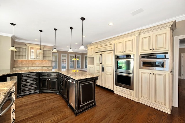 kitchen with paneled refrigerator, cream cabinets, dark wood-style floors, and stainless steel double oven