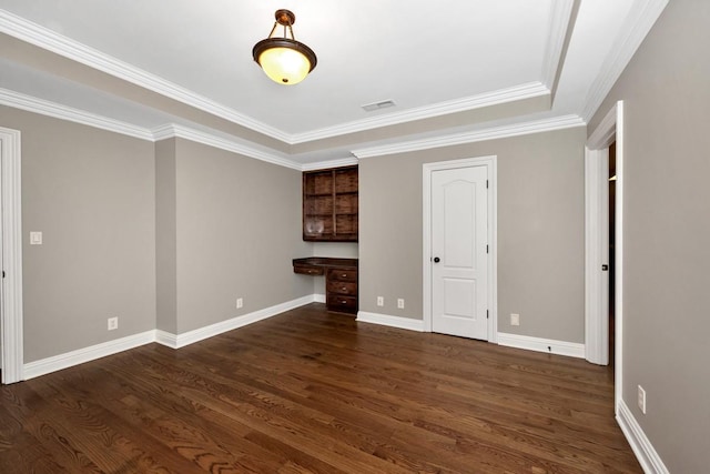 unfurnished room featuring dark wood-type flooring, baseboards, visible vents, and built in study area