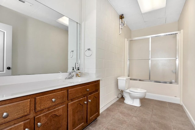 bathroom featuring tile patterned flooring, visible vents, bath / shower combo with glass door, toilet, and vanity