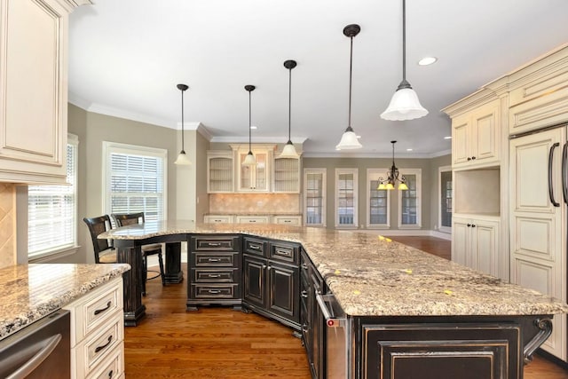 kitchen featuring crown molding, dishwasher, decorative backsplash, wood finished floors, and cream cabinetry