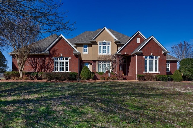 traditional-style house with brick siding and a front yard