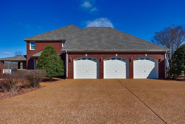 exterior space with brick siding, an attached garage, concrete driveway, and a shingled roof