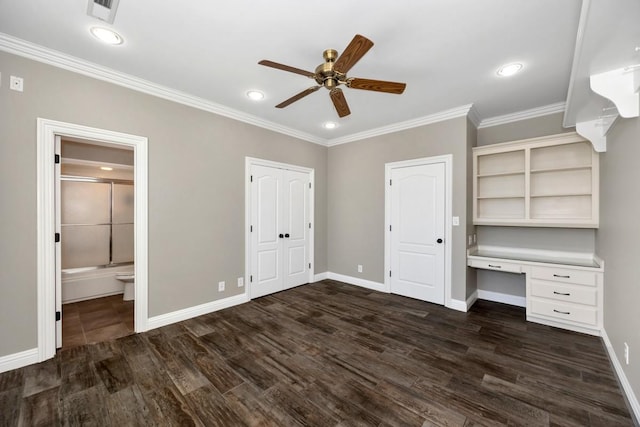 unfurnished bedroom with visible vents, dark wood finished floors, crown molding, baseboards, and built in study area