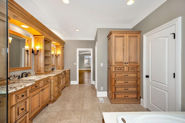 bathroom with tile patterned flooring, vanity, baseboards, and ornamental molding