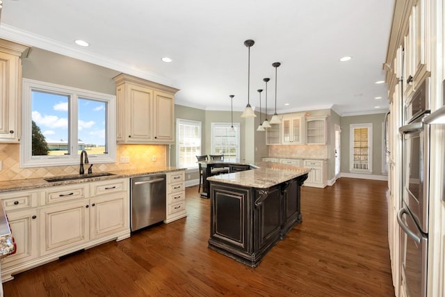 kitchen featuring cream cabinetry, dark wood-style flooring, appliances with stainless steel finishes, and a sink