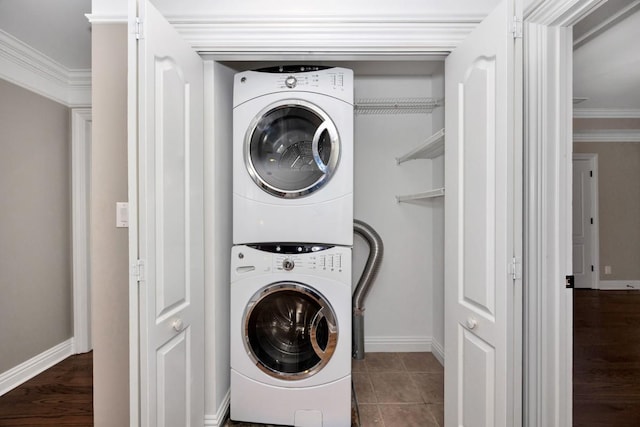 laundry area featuring laundry area, stacked washing maching and dryer, baseboards, and ornamental molding