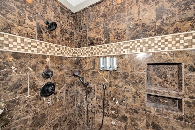 interior details with a tile shower and ornamental molding