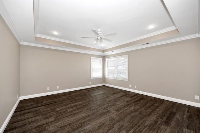 empty room featuring baseboards, visible vents, dark wood finished floors, a tray ceiling, and ceiling fan