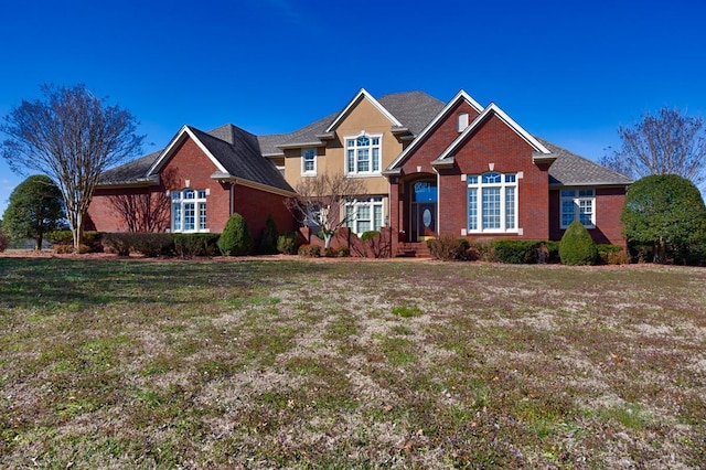 view of front of house with a front lawn and brick siding