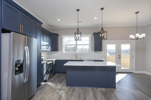 kitchen featuring a kitchen island, crown molding, appliances with stainless steel finishes, blue cabinets, and a sink