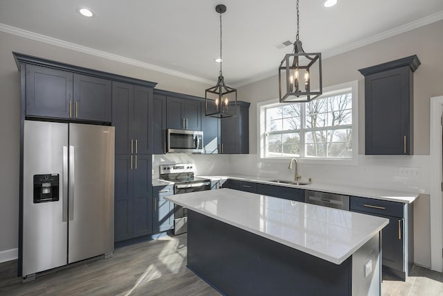 kitchen featuring visible vents, ornamental molding, a sink, tasteful backsplash, and appliances with stainless steel finishes