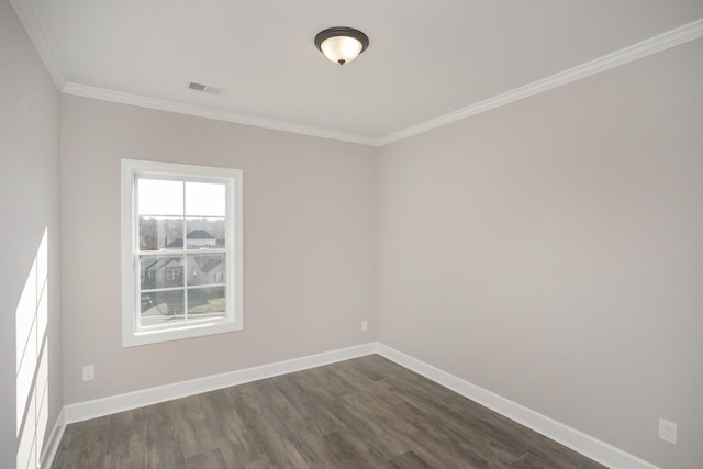 spare room featuring dark wood-type flooring, crown molding, baseboards, and visible vents