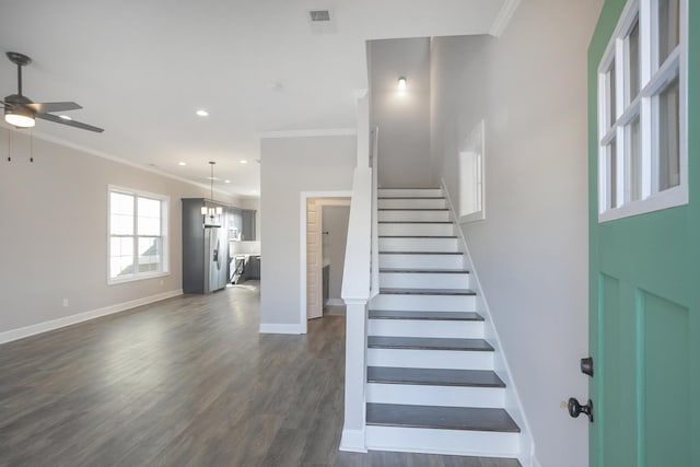 stairs featuring visible vents, wood finished floors, baseboards, and ornamental molding