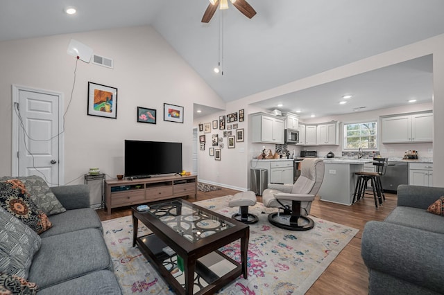 living area with wood finished floors, visible vents, high vaulted ceiling, recessed lighting, and ceiling fan