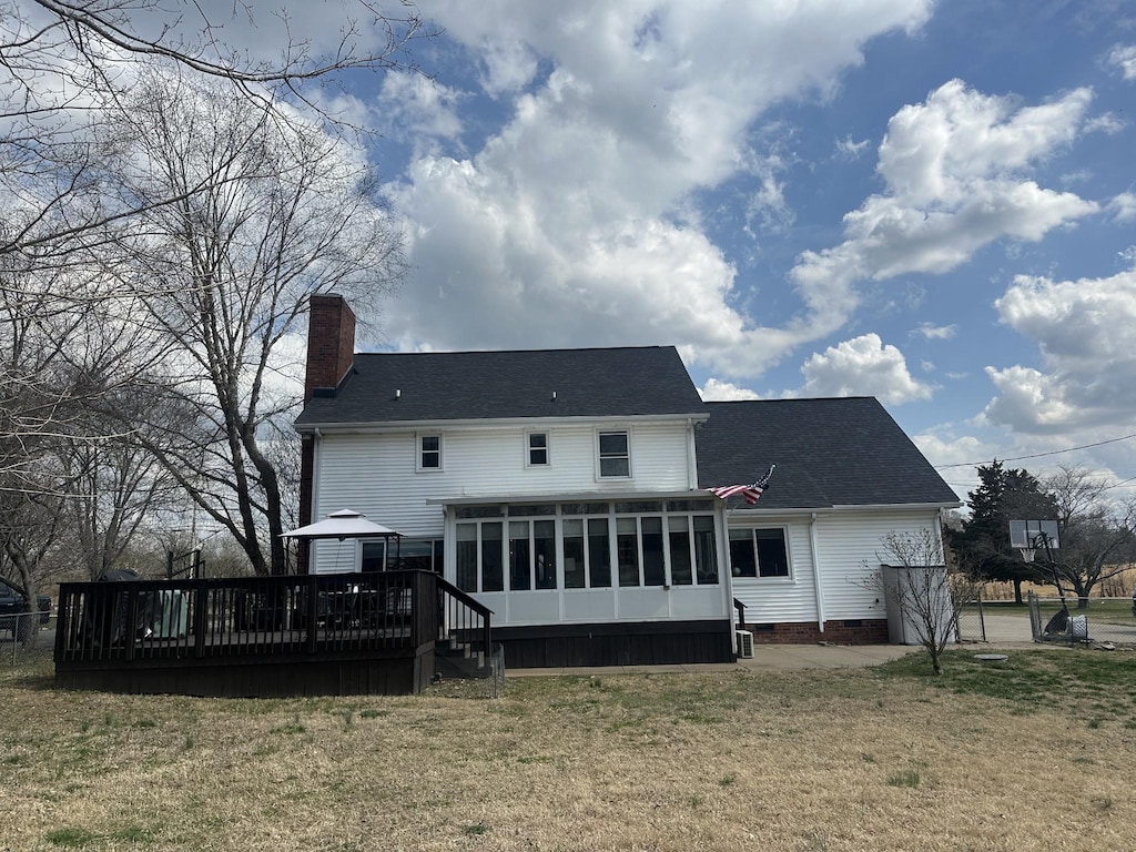 back of house with a wooden deck, a yard, a sunroom, a chimney, and crawl space