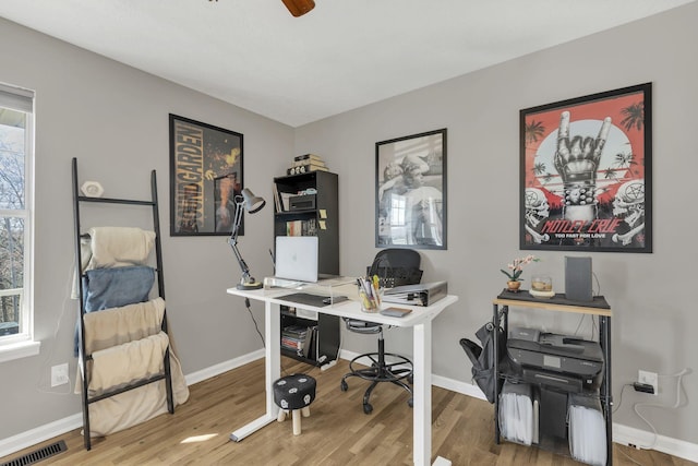 home office featuring wood finished floors, visible vents, and baseboards