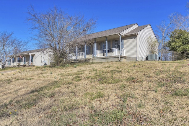 single story home featuring crawl space, central AC unit, a porch, and a front lawn