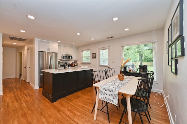 dining room with light wood-style flooring, recessed lighting, visible vents, and baseboards