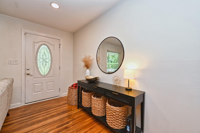 foyer featuring baseboards, lofted ceiling, and wood finished floors