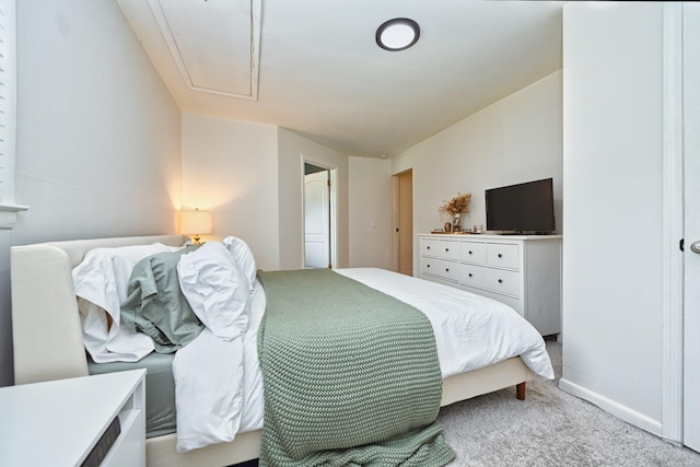 carpeted bedroom featuring attic access and baseboards