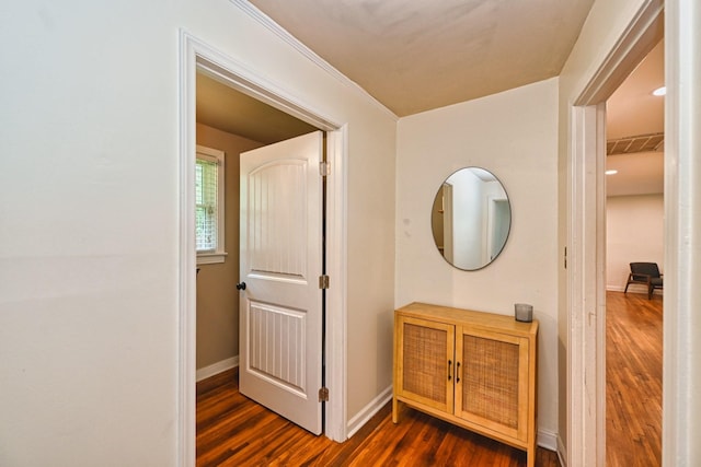 corridor featuring visible vents, baseboards, and dark wood-style floors