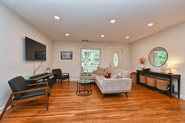 living room with visible vents, recessed lighting, light wood-type flooring, and baseboards