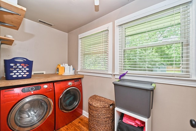 laundry area with visible vents, a ceiling fan, wood finished floors, separate washer and dryer, and laundry area