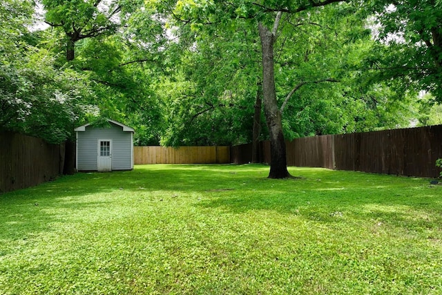 view of yard with an outbuilding, a storage shed, and a fenced backyard