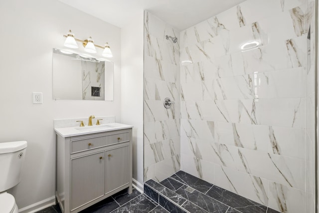 bathroom with baseboards, toilet, a tile shower, marble finish floor, and vanity