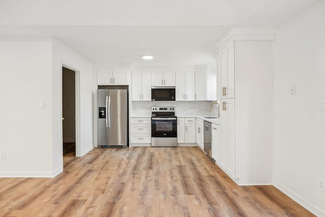 kitchen featuring a sink, tasteful backsplash, appliances with stainless steel finishes, and white cabinetry