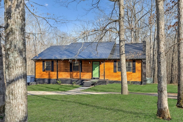 chalet / cabin with metal roof and a front yard